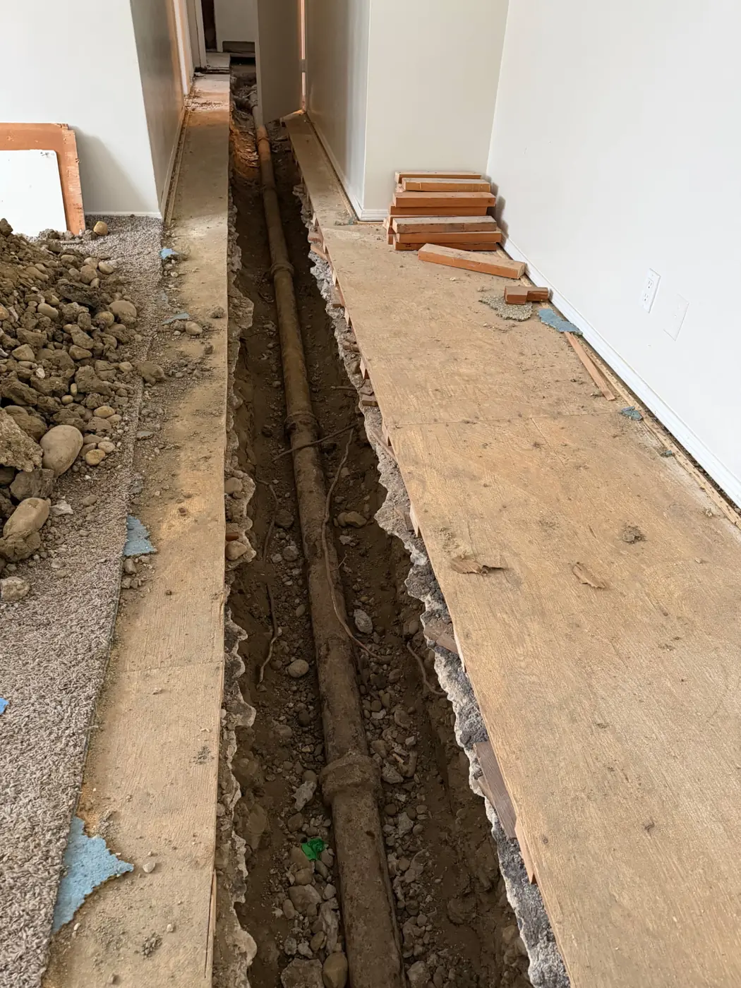 Existing drain line exposed under the floor