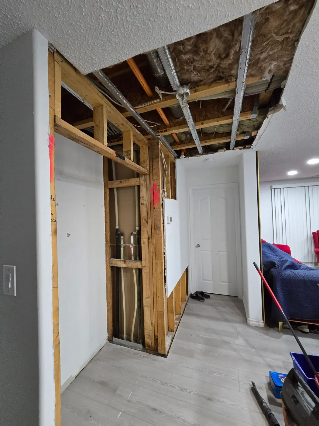 Wall & ceiling opened to reach plumbing